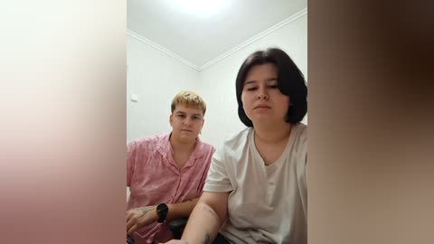 Video of two women in a narrow, dimly lit hallway; one with short blonde hair, one with dark hair.