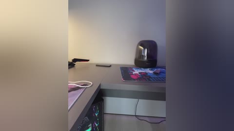 A video of a dimly lit, minimalist room featuring a black microwave, a purple mousepad, and a partially visible gaming PC.