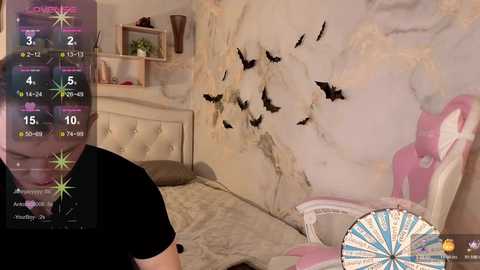 Video of a young woman in a black t-shirt, standing in a pastel-themed bedroom with a marble-effect wall featuring black bats, a pink gaming chair, and a virtual roulette wheel overlay.