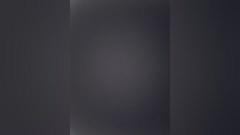 This is a digital video of a dark, grainy, and blurred background, likely taken in low light. The image is monochromatic with subtle shades of gray, creating a mysterious and somewhat eerie atmosphere.