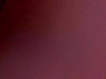 A blurry video of a reddish-brown background with subtle variations in hue, suggesting a textured, possibly wooden or fabric surface. The image lacks distinct features or objects, focusing solely on the abstract, muted color gradient.