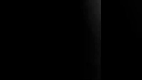 A video of a black background with a vertical, thin light beam, resembling a laser, on the right side. The beam is bright and sharply defined, creating a striking contrast against the dark backdrop.