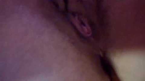 A blurred video showing a close-up of a woman's face and neck, with visible details of her parted lips and slightly visible nostrils. The image has a purple and pink hue, suggesting a soft lighting or filter effect.