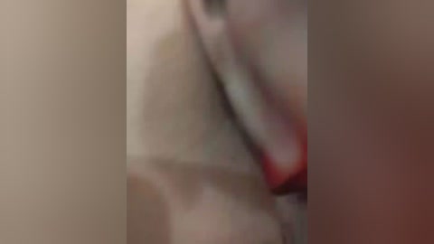 Blurry video of a close-up of a person's face and arm, with indistinct features and unclear background.