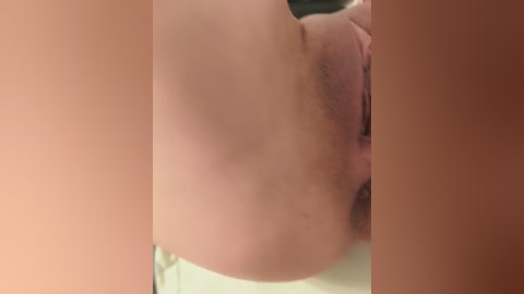 Video of a close-up of a person's upper torso, focusing on the left side of their body, including a portion of their face and shoulder. The skin tone is light with visible pores and slight blemishes.