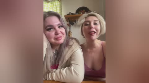 Video of two women with fair skin, one with long gray hair, another with short blonde hair, smiling, indoors with a blurred background.