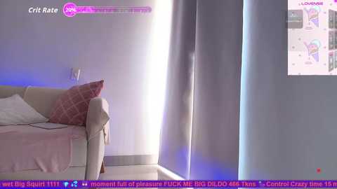 Video of a bedroom with a beige sofa and pink pillows, lit by soft purple lighting. Text overlays reveal a livestream from \"CristRate,\" with a chat featuring viewers' comments.