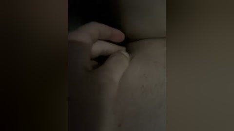 Video of a close-up, dimly-lit view of a person's hand gripping the edge of a bathtub, with a blurred, pale body partially visible.