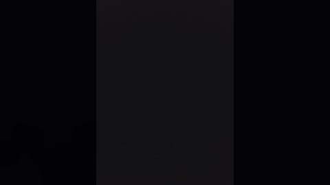 A dark, monochromatic video featuring a vertical, central black stripe against a black background. The image has a minimalistic, abstract aesthetic, with no discernible objects or textures, emphasizing stark contrast and simplicity.