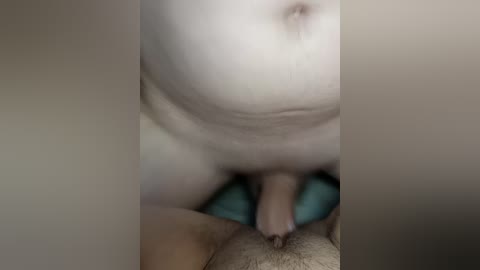Video of a close-up, intimate scene showing a white person's large, round belly and erect penis, with a teal towel visible beneath them.