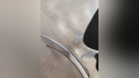 A close-up video of a sleek, silver metallic car door handle, with blurred background suggesting a modern, minimalist interior. The image emphasizes the smooth, reflective texture of the handle.