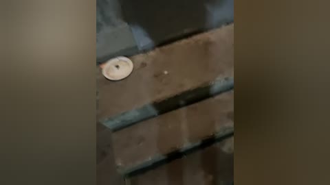 A video depicting a close-up view of a rusted, brownish-brick wall with a round, white, rusted metal object embedded in the middle, creating a gritty, industrial aesthetic.