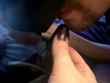 Video of a close-up hand applying black nail polish to a fingernail, blurry background, suggesting a casual indoor setting.